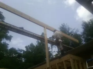 Carpenter setting a ridge beam over a new addition frame — Ice Dam Removal by Roofing Brothers in Bradfordwoods