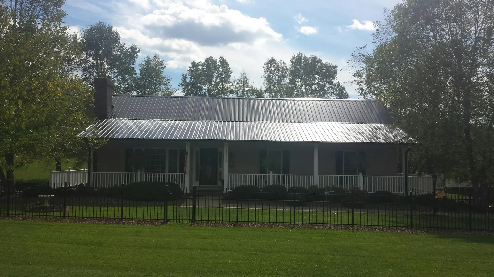 Gray metal roof on a brick ranch with a full width front porch — Gutter Guard Installation work by our crew in Bradfordwoods